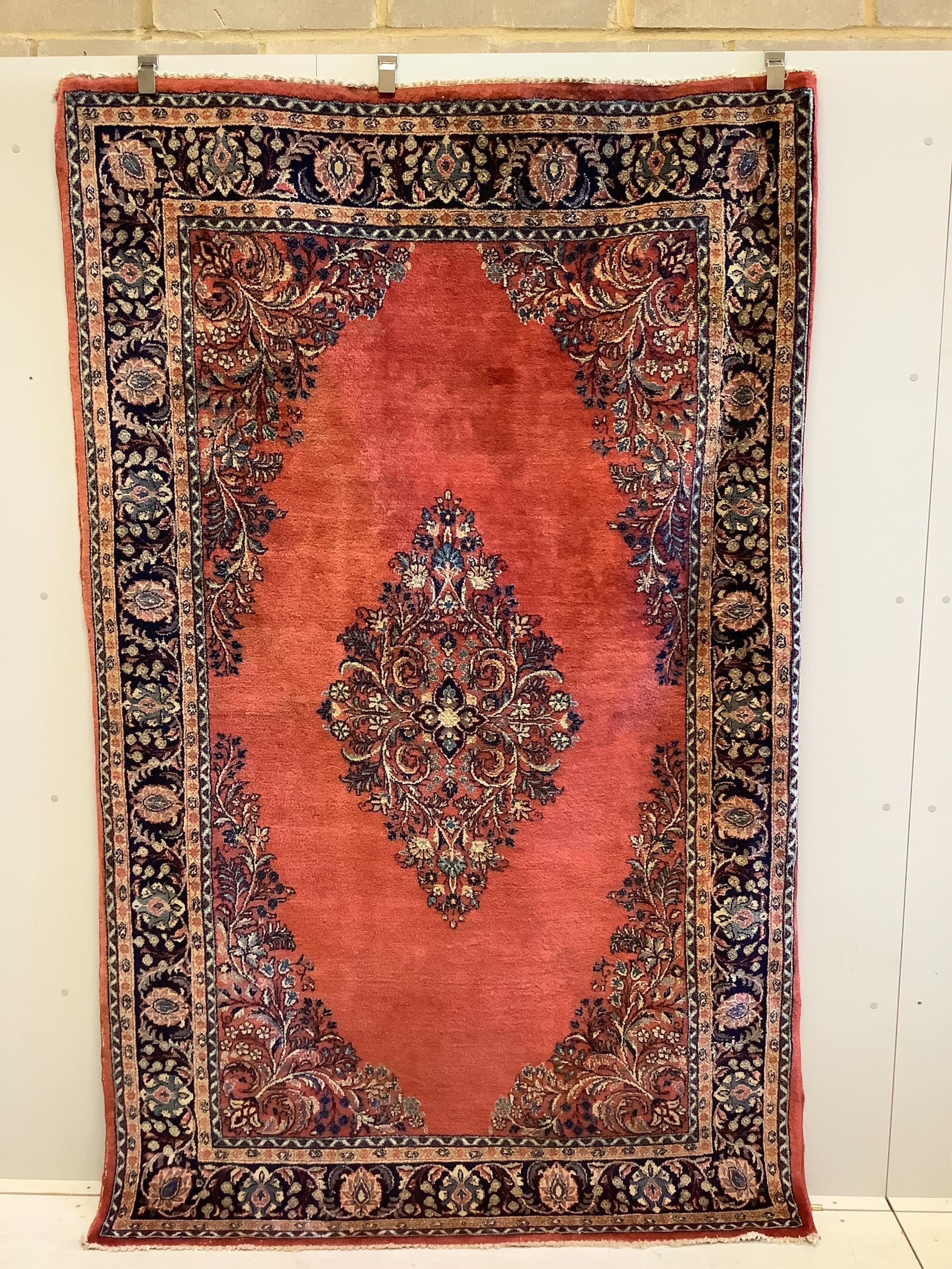 A Sarouk red ground rug, 244 x 151cm